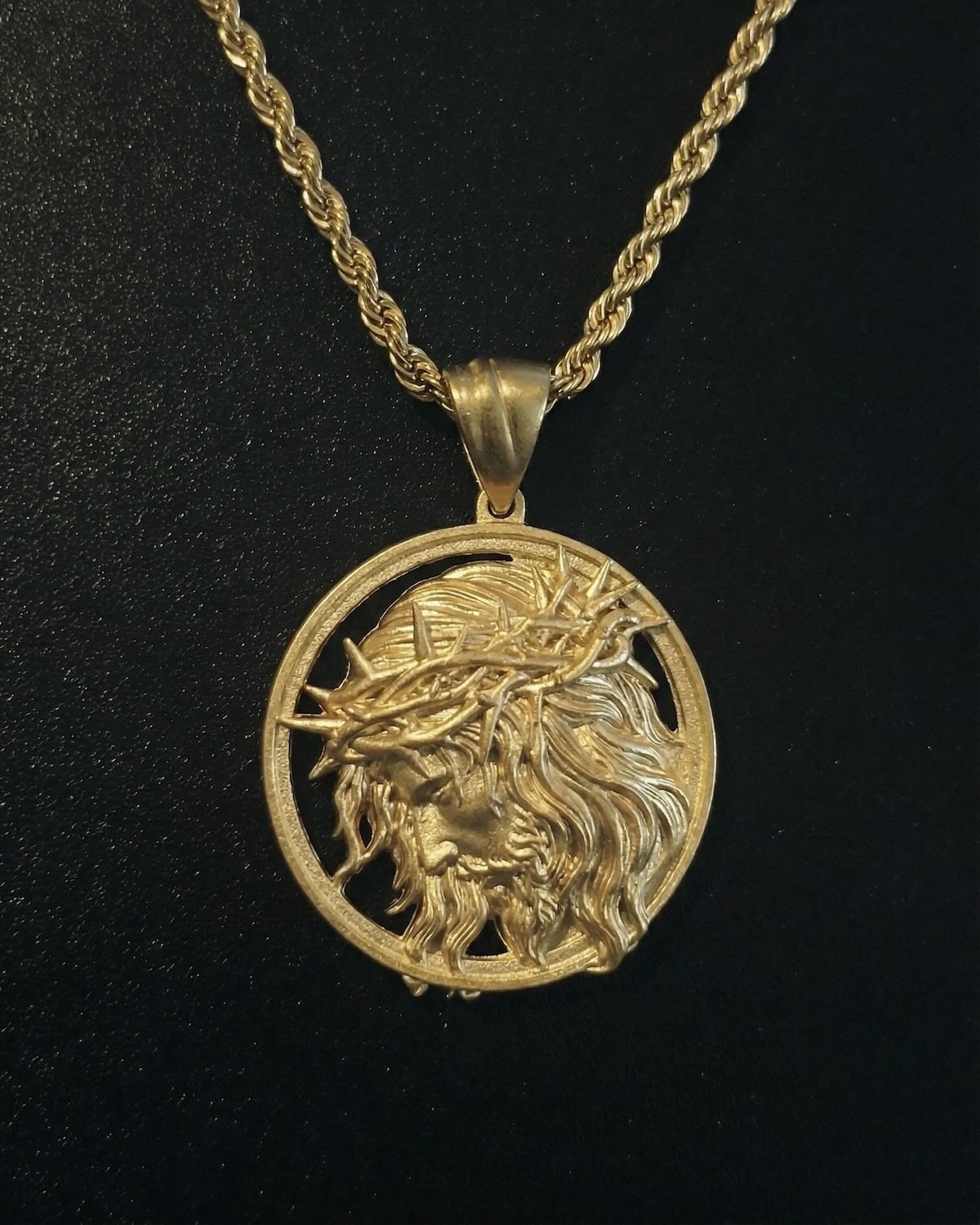 Gold Jesus head medallion pendant with the face of Christ in profile and a cut-out crown of thorns ring, close detail
