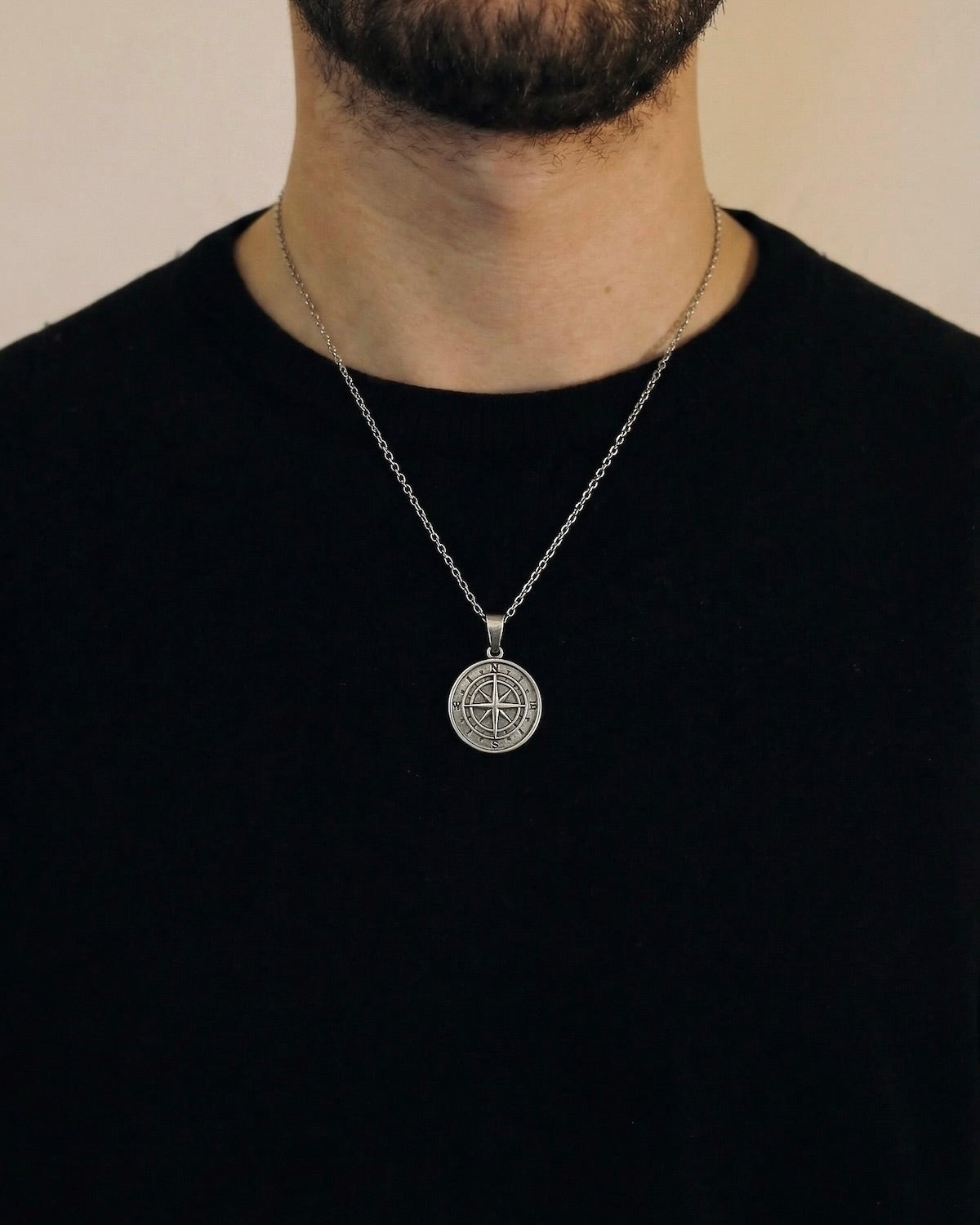 Man wearing a silver compass necklace on a 50cm chain over a black t-shirt