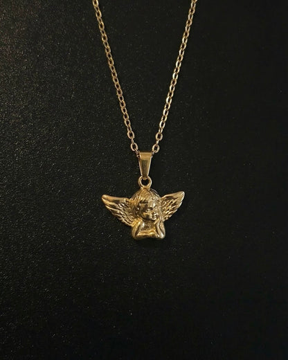 Gold angel pendant shaped into a 3D cherub with spread feathered wings, close detail