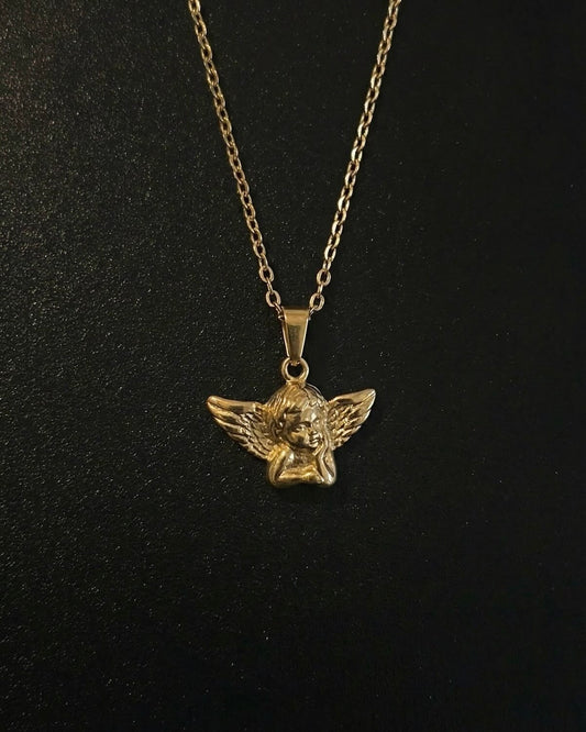 Gold angel pendant shaped into a 3D cherub with spread feathered wings, close detail