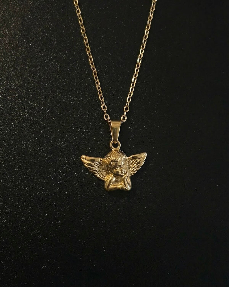 Gold angel pendant shaped into a 3D cherub with spread feathered wings, close detail