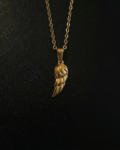 Gold angel wing pendant with layered feathers and a polished finish, close detail