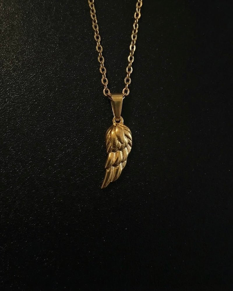 Gold angel wing pendant with layered feathers and a polished finish, close detail