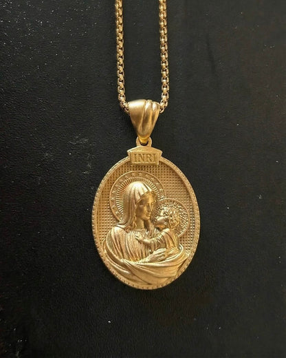 Gold baby Jesus pendant showing the Madonna holding the haloed infant Christ on an oval medallion with an INRI tablet, close detail