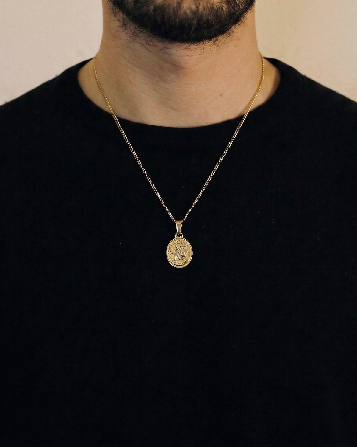 Man wearing a gold centurion necklace on a 50cm chain over a black t-shirt