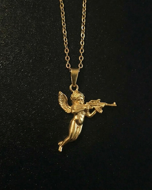 Gold cherub pendant shaped into a winged baby angel in flight holding a rifle, close detail