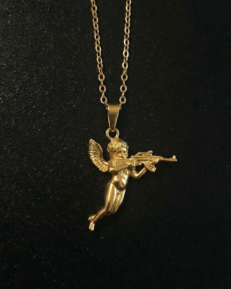 Gold cherub pendant shaped into a winged baby angel in flight holding a rifle, close detail