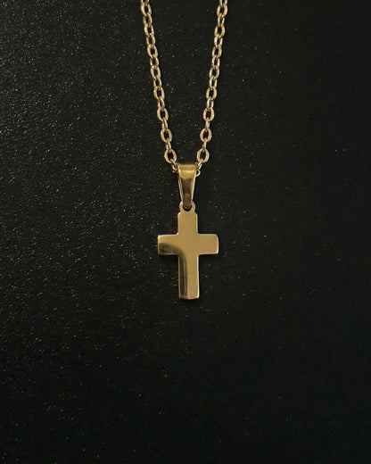 Gold cross pendant in a compact size with a polished mirror finish, close detail