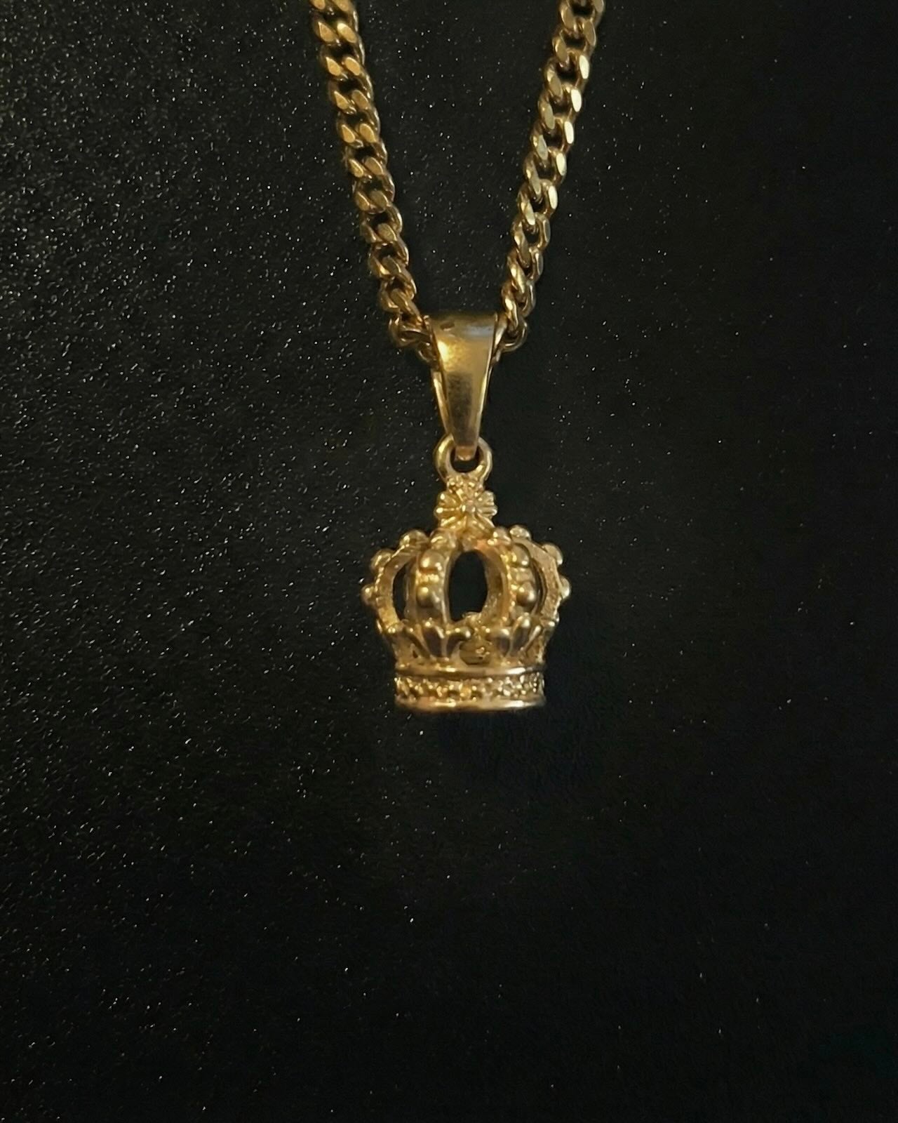 Gold crown pendant shaped into a 3D royal crown with beaded detail, close detail