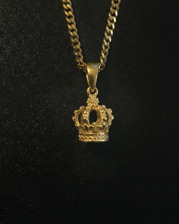 Gold crown pendant shaped into a 3D royal crown with beaded detail, close detail