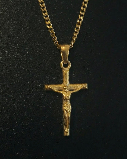 Gold crucifix pendant with the figure of Christ on a slim cross, close detail