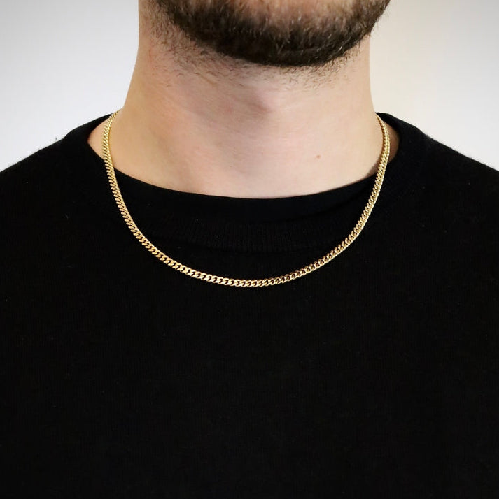 4mm gold Cuban link chain worn by a man over a black t-shirt