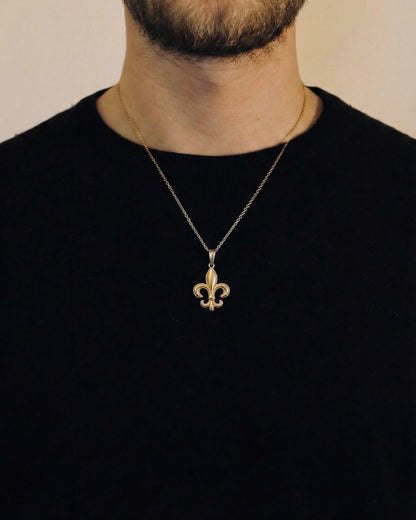 Man wearing a gold fleur-de-lis necklace on a 50cm chain over a black t-shirt