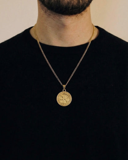 Man wearing a gold Greek Zeus necklace on a 50cm chain over a black t-shirt