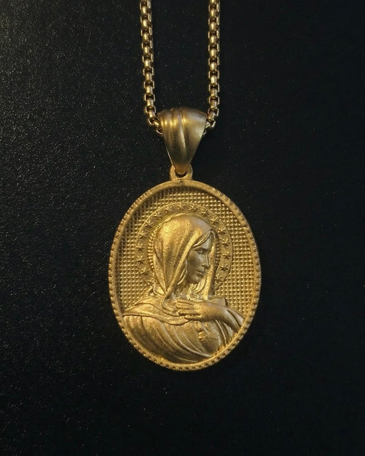 Gold Holy Mary pendant with Mary in side profile and a hand on her chest, ringed by stars, close detail