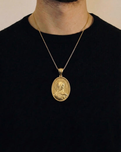 Man wearing a gold praying virgin mary necklace on a 50cm chain over a black t-shirt