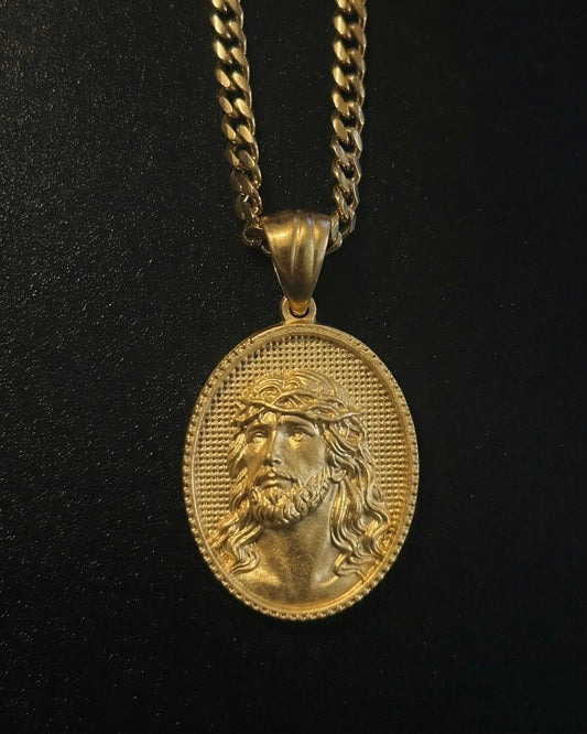 Gold Jesus coin pendant with a front-facing portrait of Christ and crown of thorns on an oval medallion, close detail