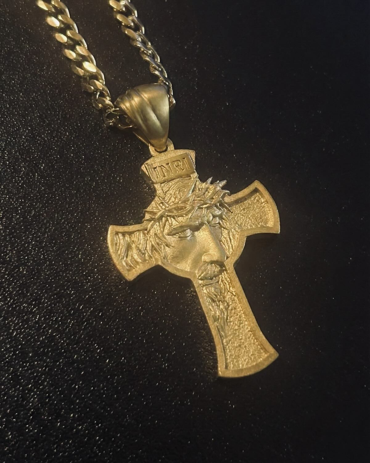 Gold Jesus face cross pendant with the face of Christ in the crown of thorns and an INRI tablet, close detail