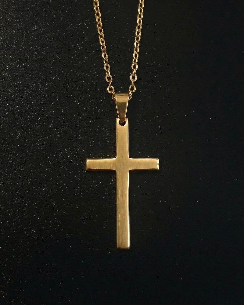 Gold minimalist cross pendant with a slim flat brushed finish, close detail