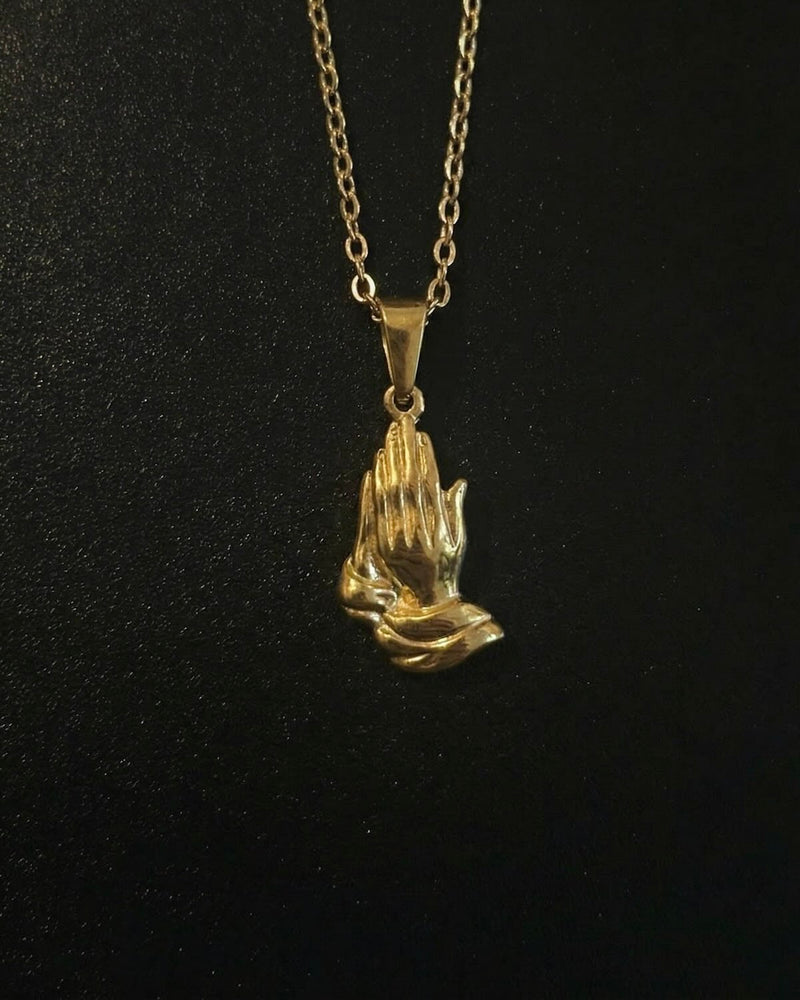 Gold praying hands pendant sculpted in 3D detail, close detail