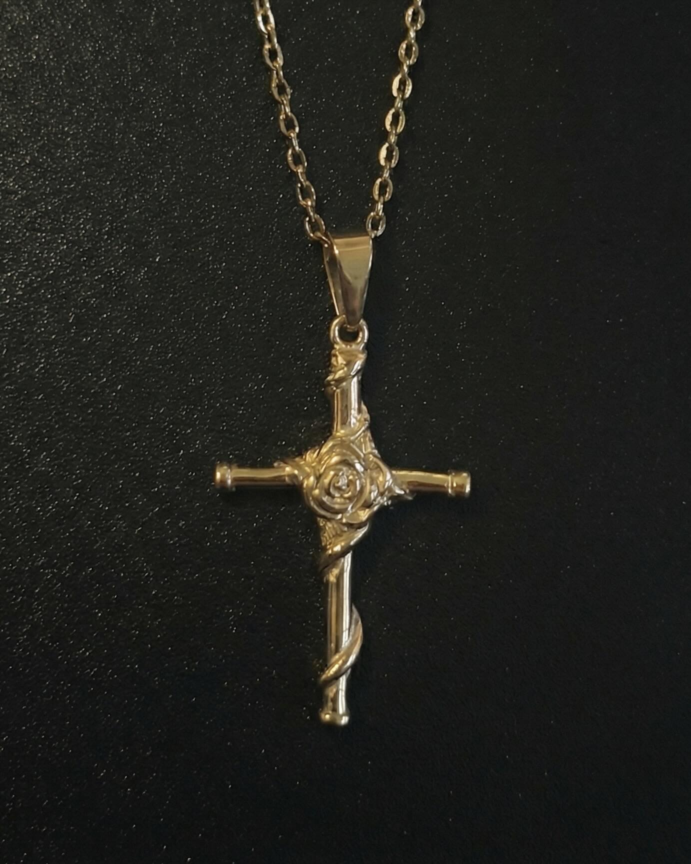 Gold rose cross pendant with a sculpted rose and vine down the lower arm, close detail