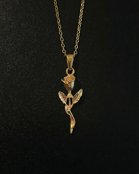 Gold rose pendant shaped into a long-stemmed rose with a sculpted bud and leaves, close detail