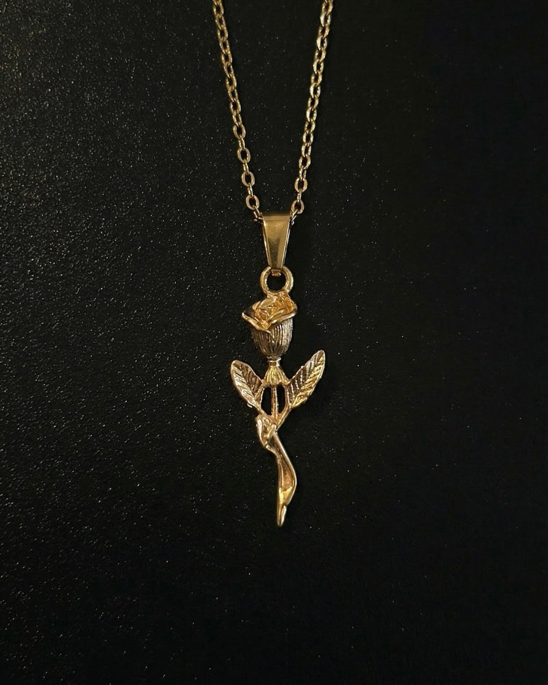 Gold rose pendant shaped into a long-stemmed rose with a sculpted bud and leaves, close detail
