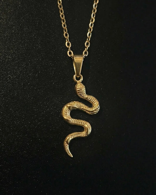 Gold snake pendant shaped into a coiled serpent in an S-curve with textured scales, close detail