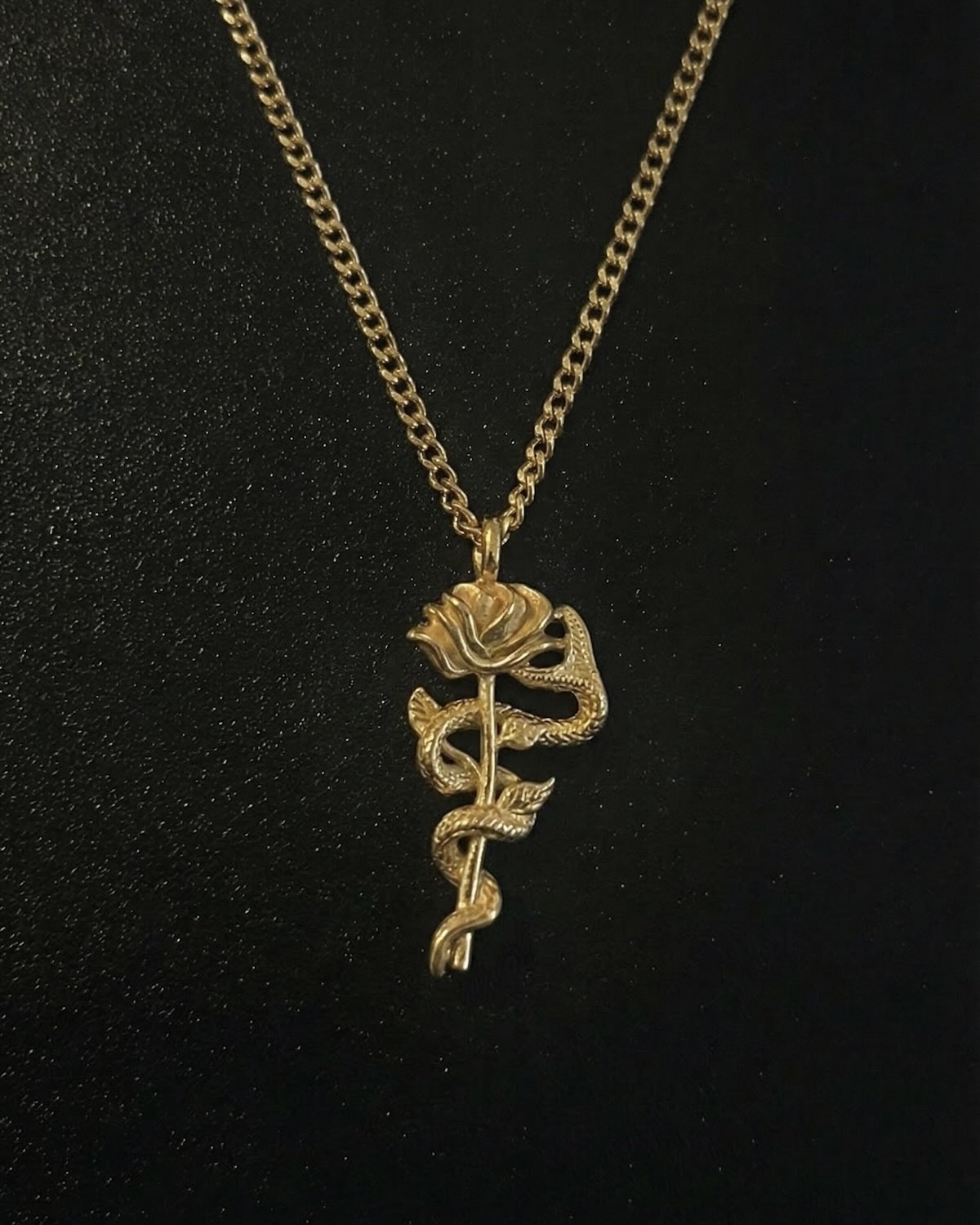 Gold snake rose pendant with a serpent coiled around a long-stemmed rose, close detail