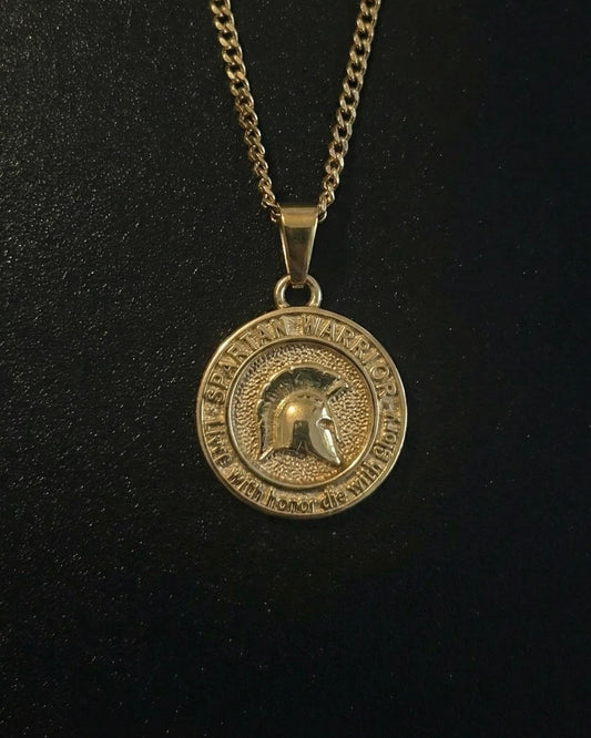 Gold Spartan warrior pendant with a helmet in profile and inscription ring, close detail