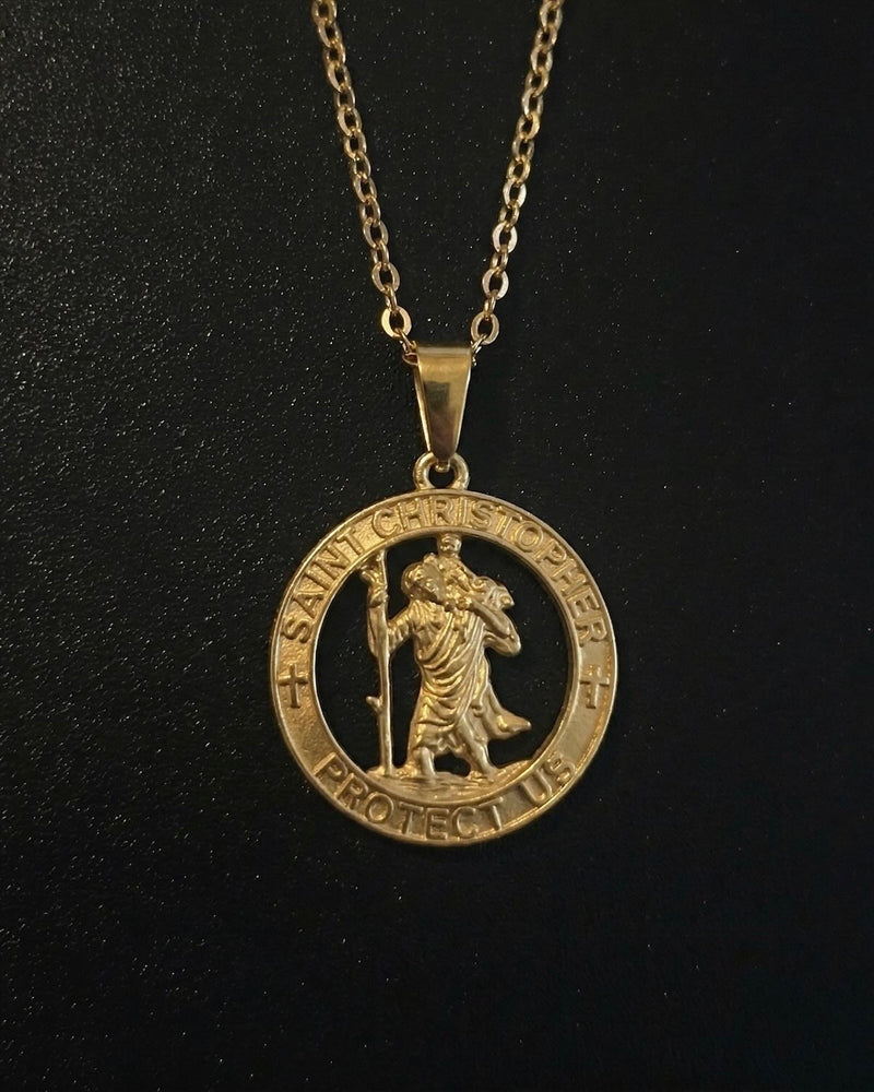 Gold St Christopher pendant with an open cut-out medallion and protect-us inscription, close detail