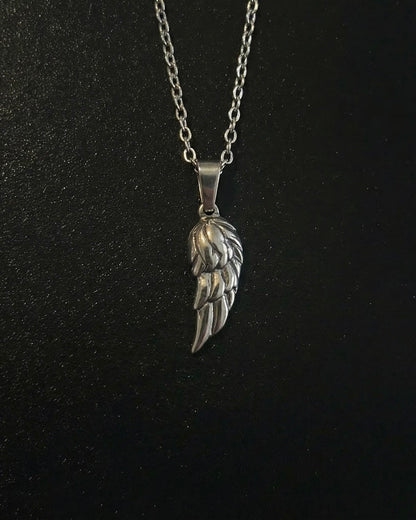 Silver angel wing pendant with layered feathers and an antiqued finish, close detail