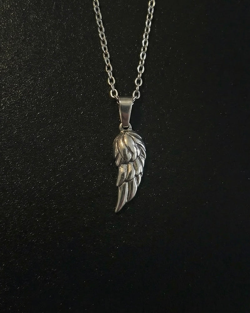 Silver angel wing pendant with layered feathers and an antiqued finish, close detail