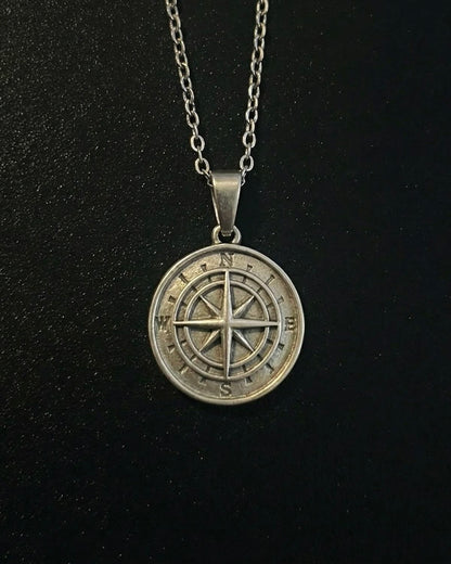 Silver compass pendant with a compass rose and eight-point star, close detail