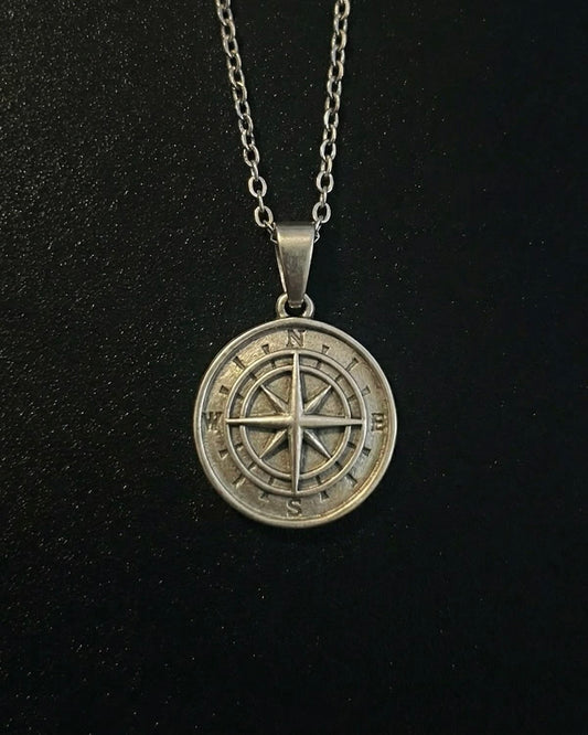Silver compass pendant with a compass rose and eight-point star, close detail