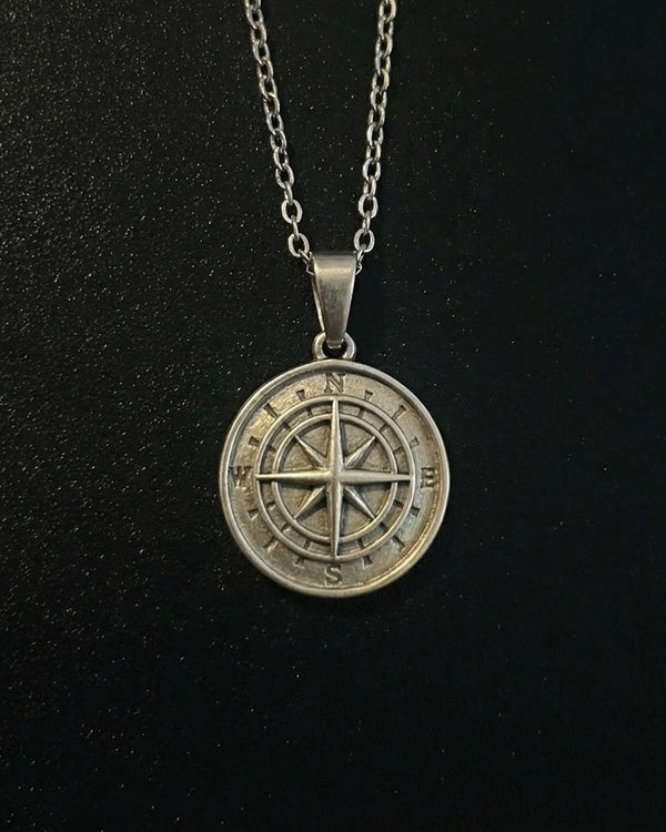 Silver compass pendant with a compass rose and eight-point star, close detail