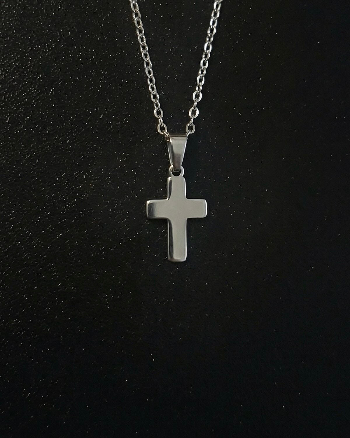 Silver cross pendant in a compact size with a polished mirror finish, close detail