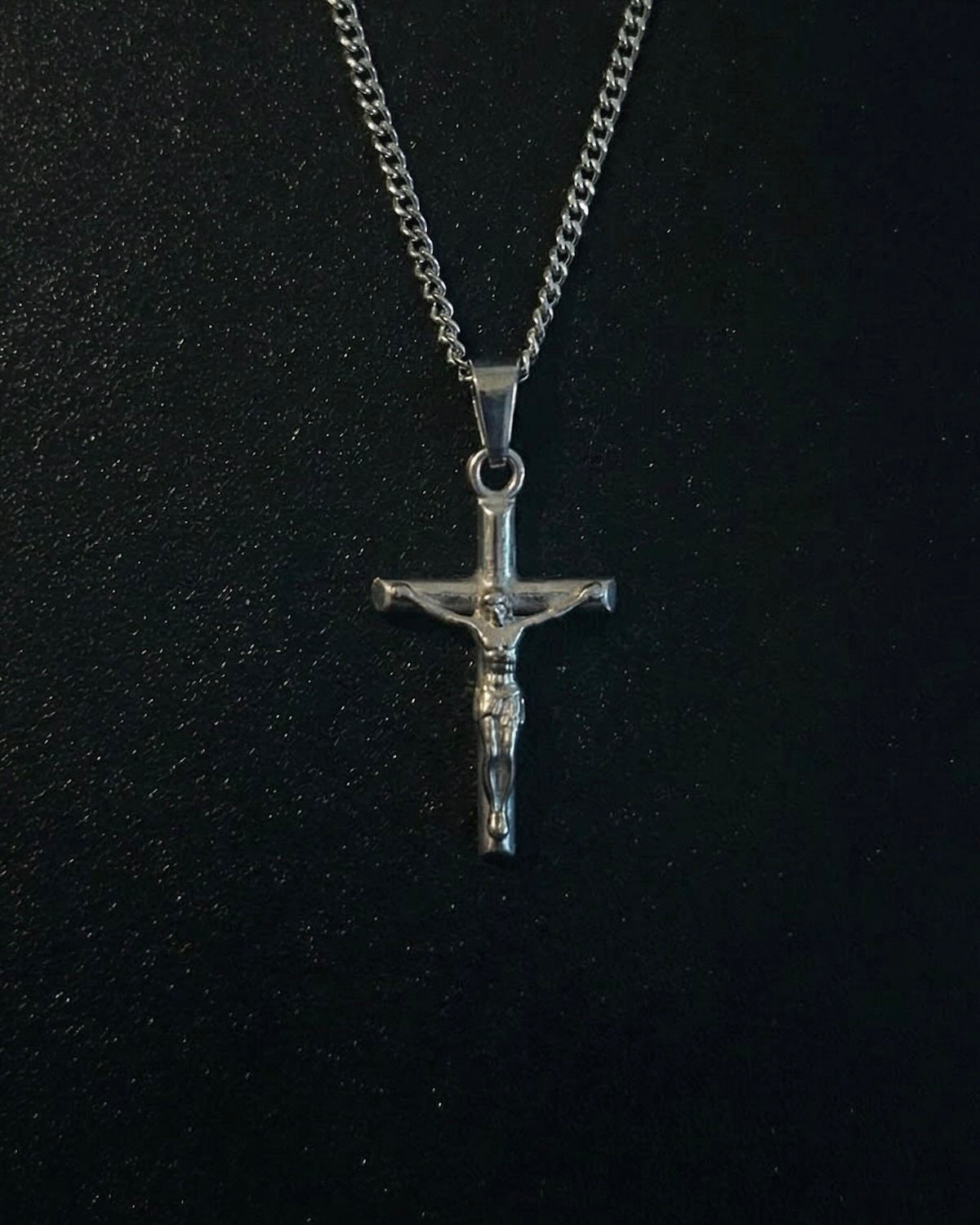 Silver crucifix pendant with the figure of Christ on a slim cross, close detail