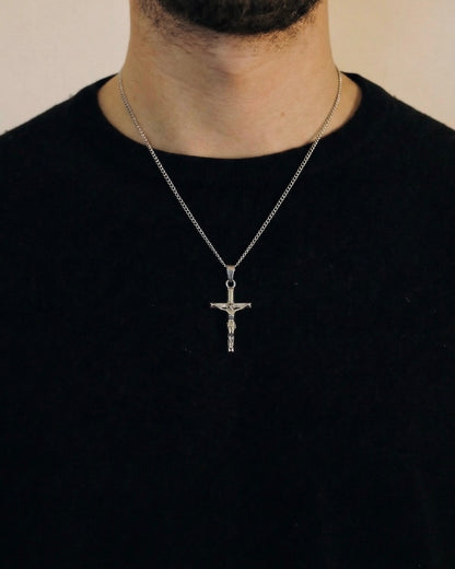 Man wearing a silver crucifix necklace on a 50cm chain over a black t-shirt
