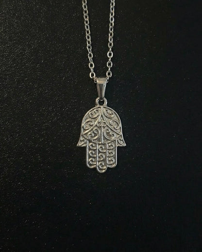 Silver hamsa hand pendant with detailed filigree scrollwork, close detail