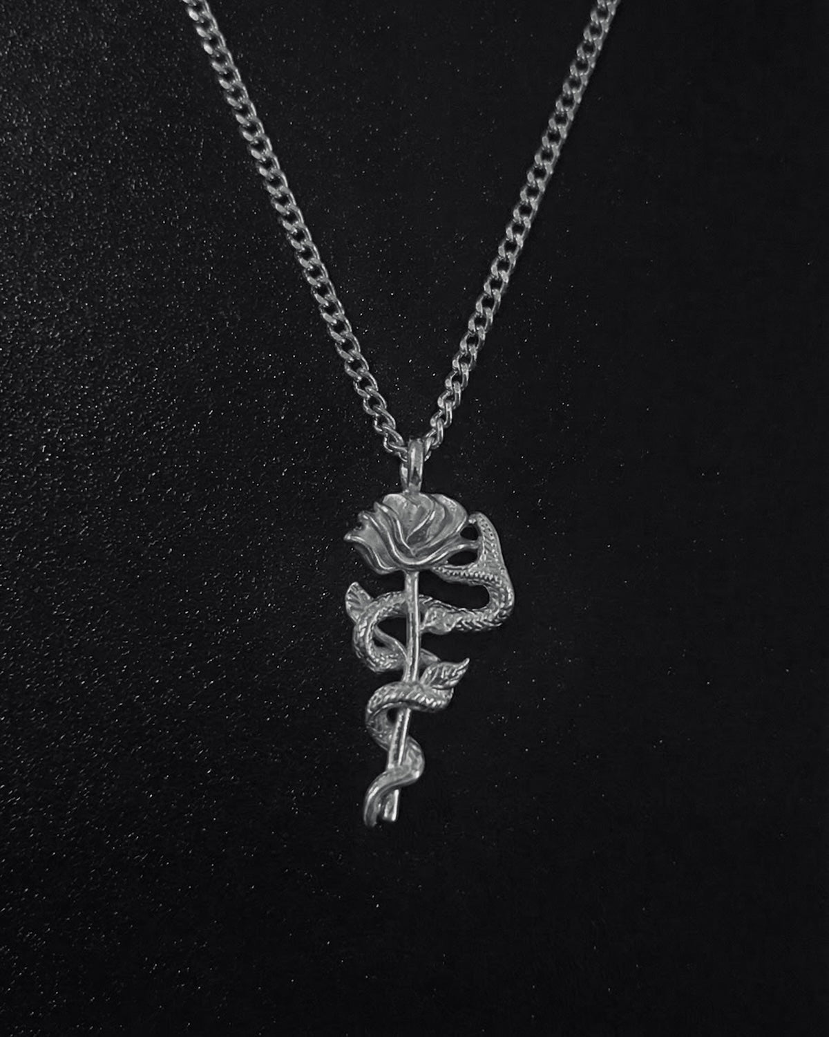 Silver snake rose pendant with a serpent coiled around a long-stemmed rose, close detail