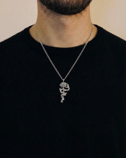 Man wearing a silver snake rose necklace on a 50cm chain over a black t-shirt