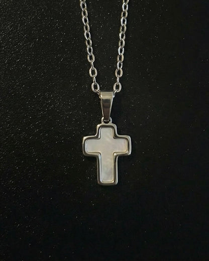 Silver trimmed cross pendant with a steel frame and mother-of-pearl center, close detail