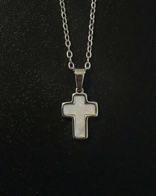 Silver trimmed cross pendant with a steel frame and mother-of-pearl center, close detail